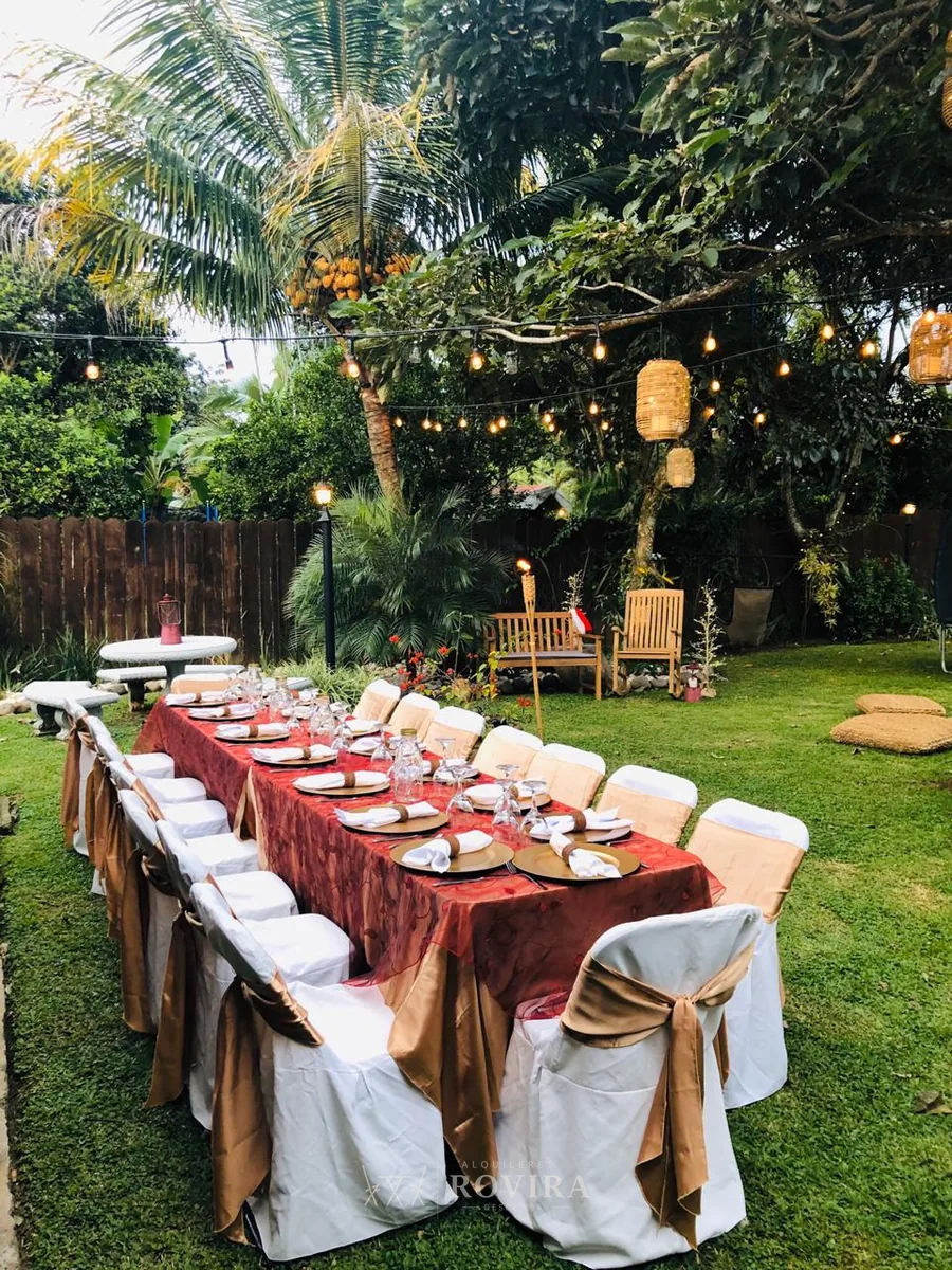 Montaje navideño en jardín con mesa larga vestida en dorado