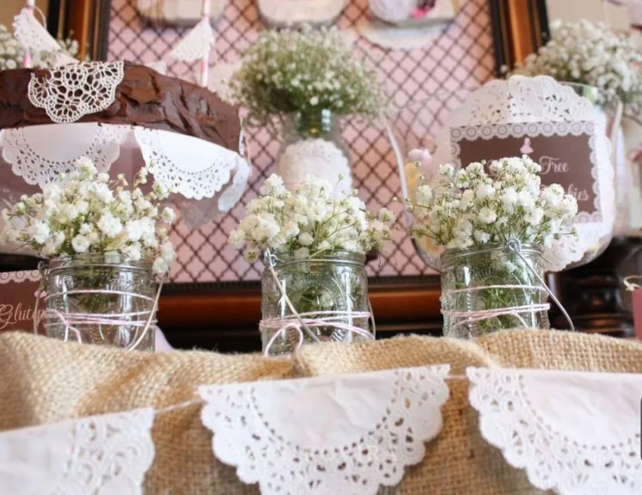 Mesa de postres vintage con baby's breath y carpetas de blonda