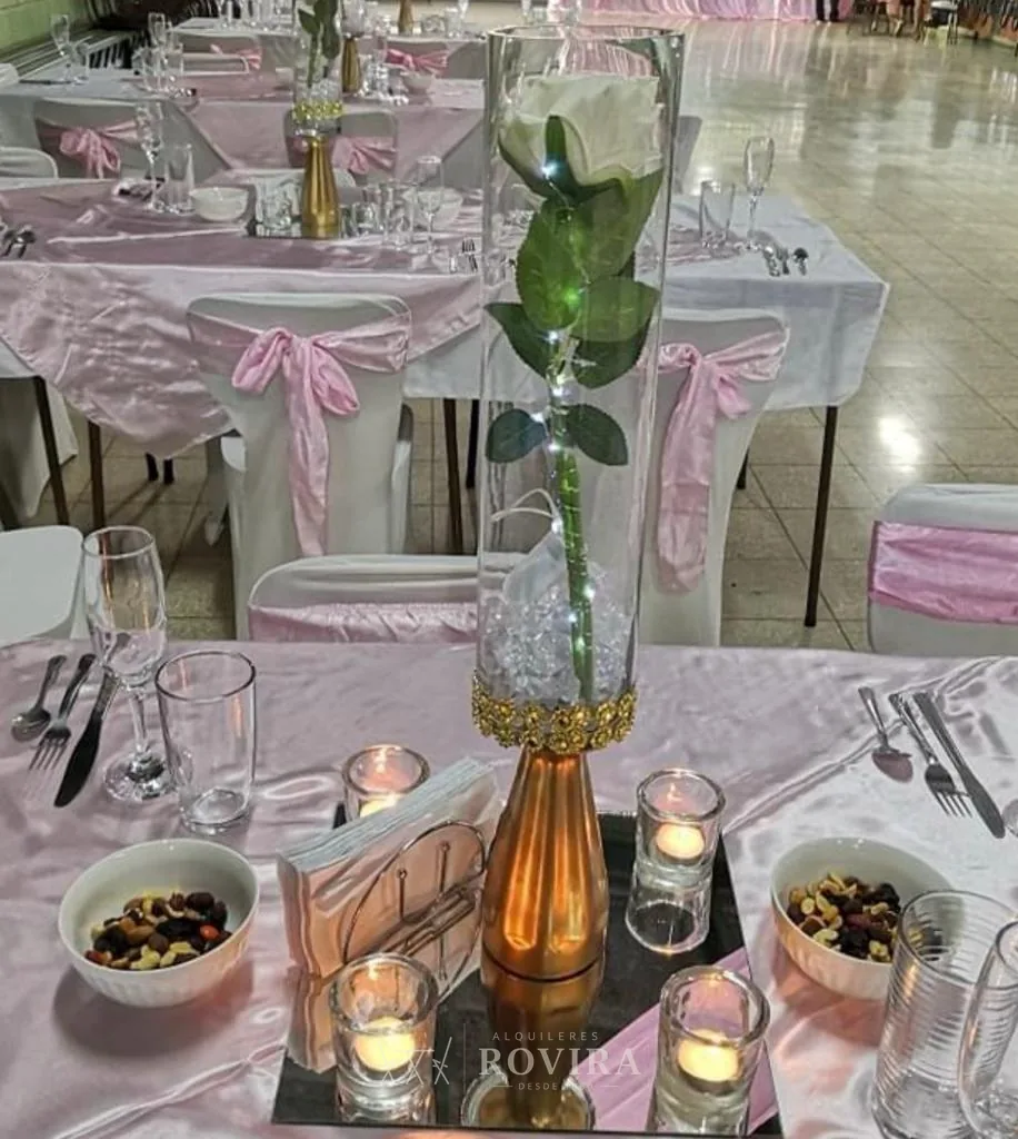 Montaje de mesa con centro decorativo y velas, evento vestido
