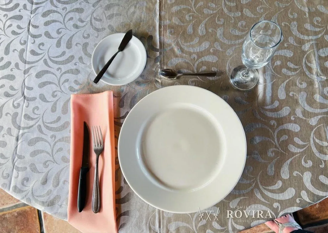 Mise en place con mantel damasco gris, copa de vino y plato blanco sencillo