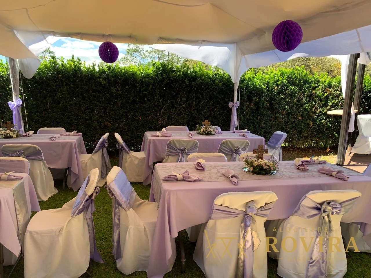 Baby shower con mesas vestidas en lila y lavanda y forros de silla blancos, montaje al aire libre