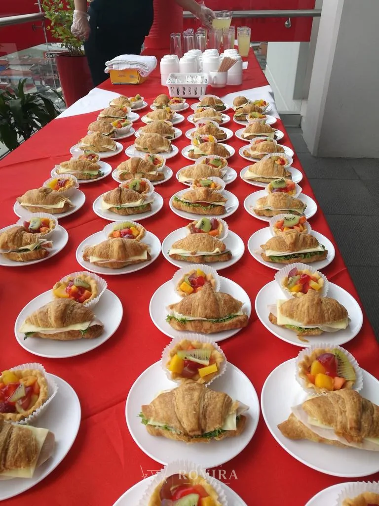 Bocadillos servidos sobre mantel rojo, montaje de catering festivo