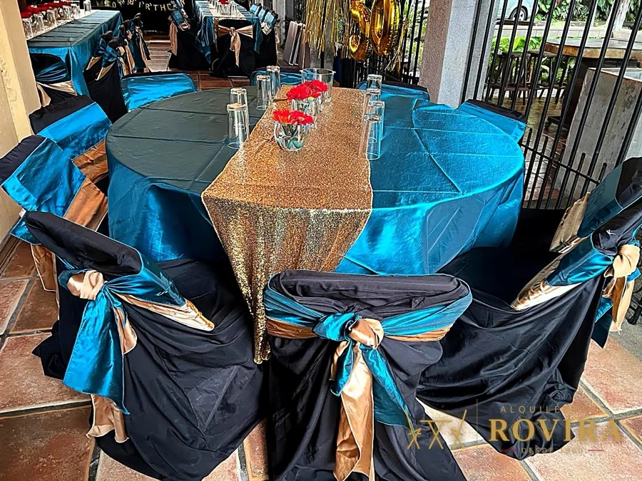 Mesas redondas en turquesa y dorado con lazos negros, montaje elegante