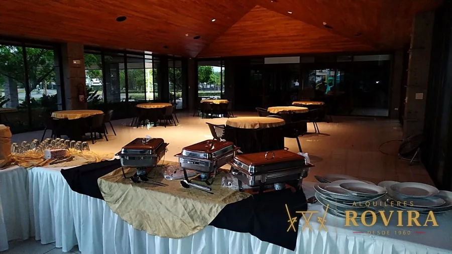 Salón rústico con mesas montadas y ventanales