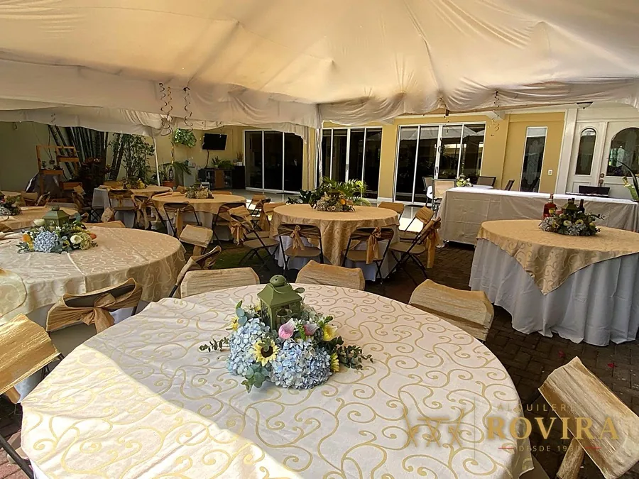 Salón con techo drapeado y mesas redondas elegantes