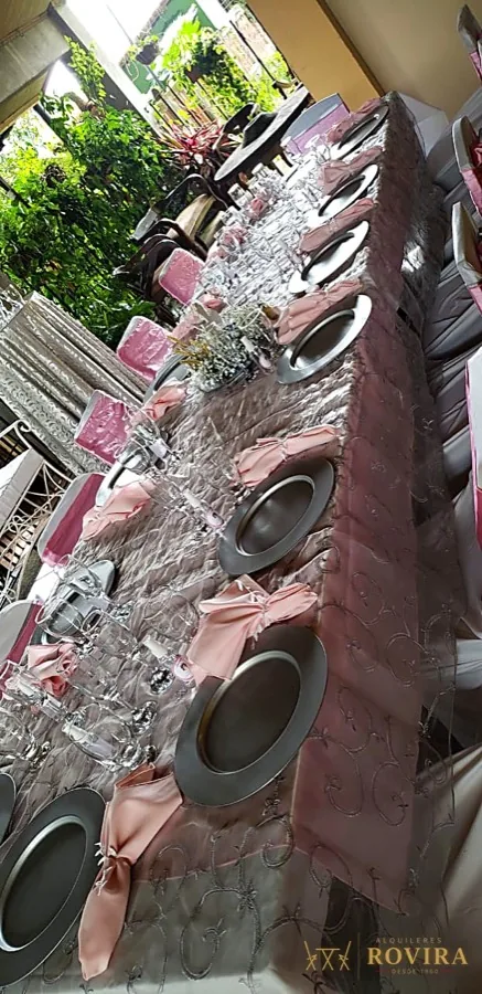 Cristalería y vajilla envuelta con lazos rosados, detalle de montaje